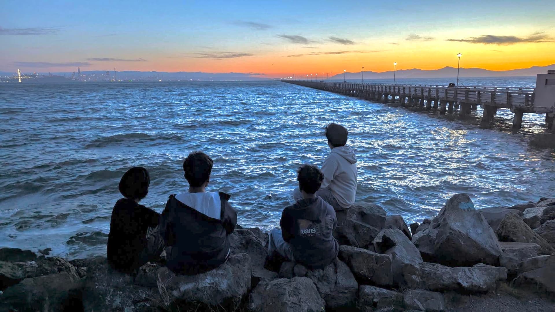 Friends watching the sunset at a pier